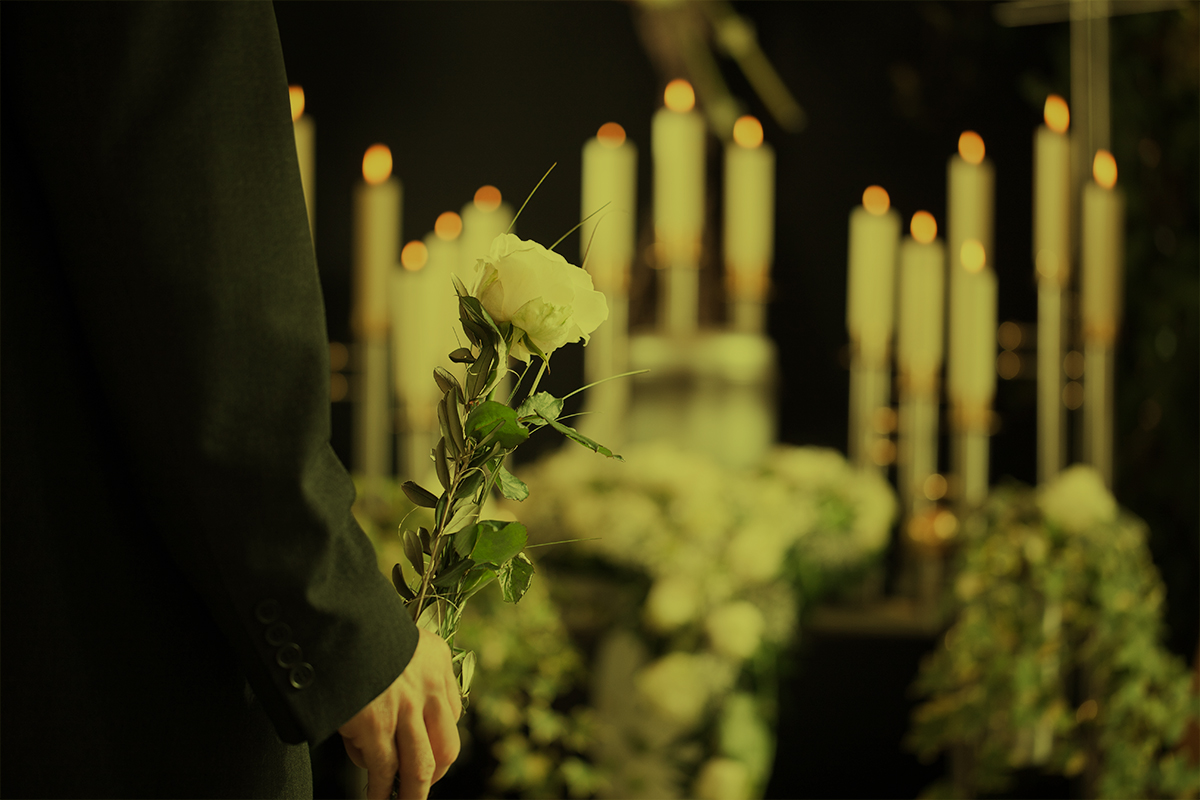 Religion, death and dolor  - man at funeral with white rose mourning the dead